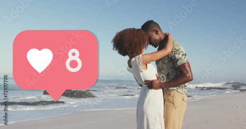 Heart icon with increasing numbers against african american couple embracing each other on the beach