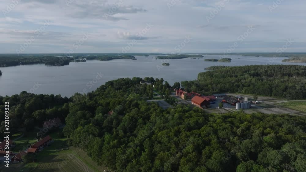 Aerial - Forward panning drone shot of Taxinge Castle by forest and lake. 