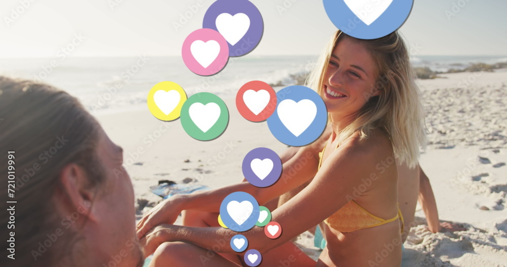 Image of heart digital icons over friends having fun on beach