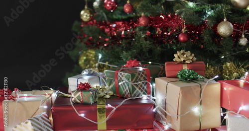 Colorful wrapped gifts sit under a decorated Christmas tree