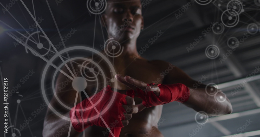 Fototapeta premium Image of network of connections over man tying ribbons on his hands