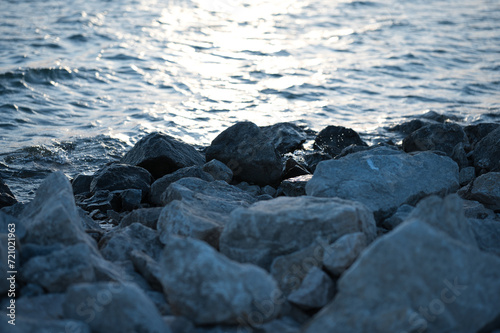 rocks on the shore next to the water at sunsets