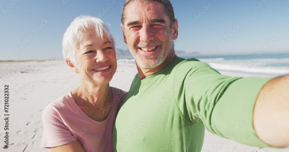 Image of social media email icon over senior woman kissing her husband on beach