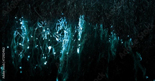 A wave of blue glowing electrical energy rises from the bottom to the top, throwing around sparks and leaving behind blobs of burnt material photo