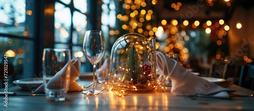 Christmas decoration with fairy lights and paper napkins placed under glass dome on cafe table.