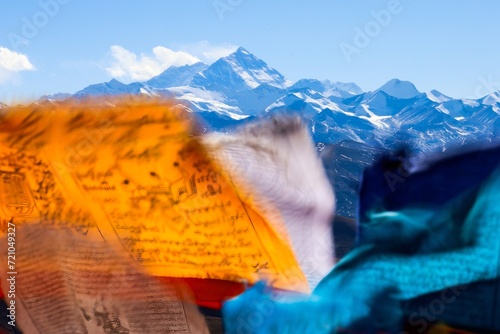 Experience the breathtaking grandeur of Mt. Everest as Tibetan prayer flags flutter in the wind, creating a colorful tapestry at Pang La pass (5248 m) near Tingri, Tibet. 
