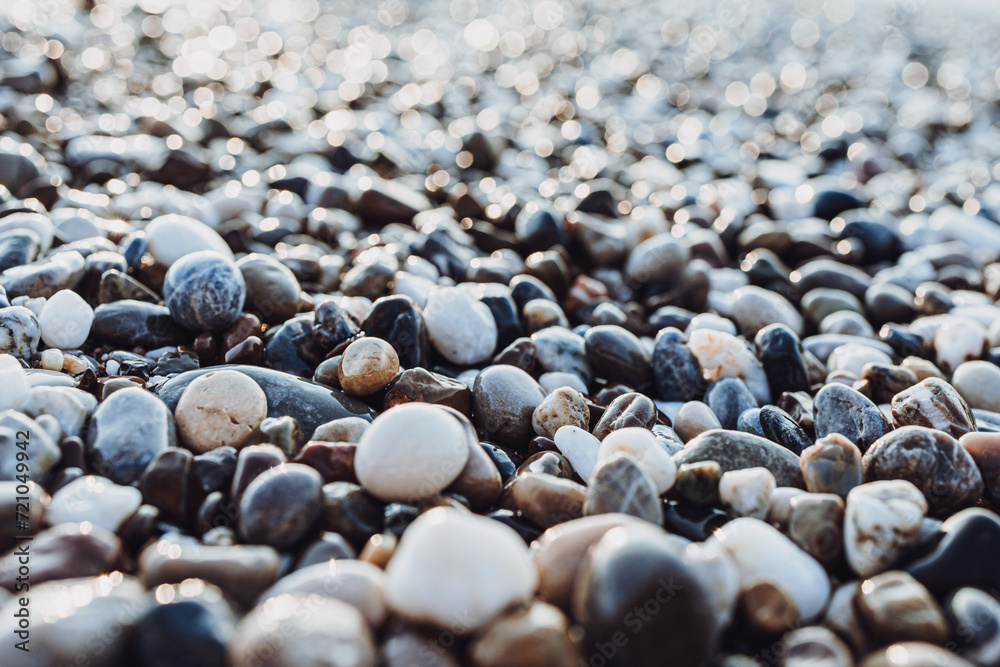 background of pebbles on the sea. Mediterranean coastal area. small sea stones. pebbles close up. photo of stones with bokeh effect