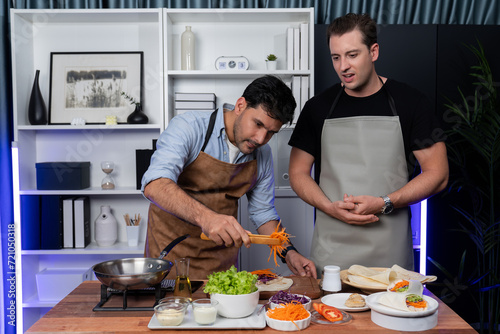 Healthy influencers presenting fresh salad roll power on cooking show, displaying ingredients of diversity vegetables and homemade soft tortilla wrap on table. Channel on social media live. Sellable.