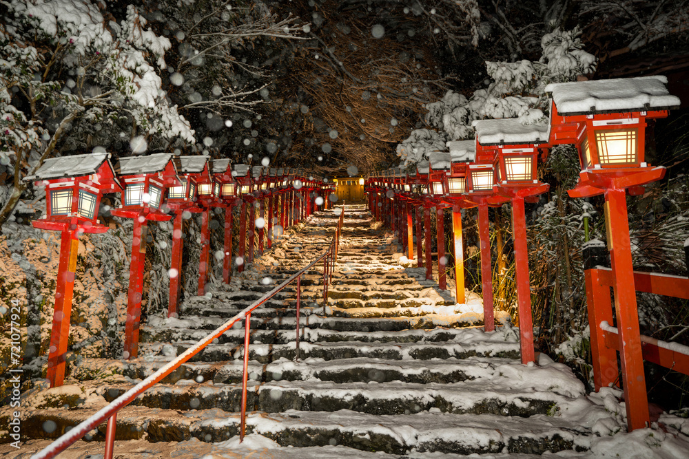 Kifune shrine stone stairs and traditional light pole in snowy winter night, Kyoto, Japan.