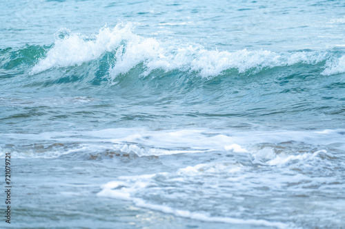 Turquoise waves across expansive frame of ocean, creating mesmerizing seascape. deep azure sea stretches to horizon, showcasing rhythmic beauty of undulating waves against serene marine backdrop