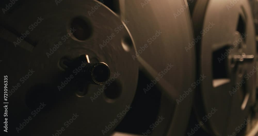 Retro-style recorder spool is spinning fast in a blinking light Retro-style recorder spool is spinning fast in a blinking light