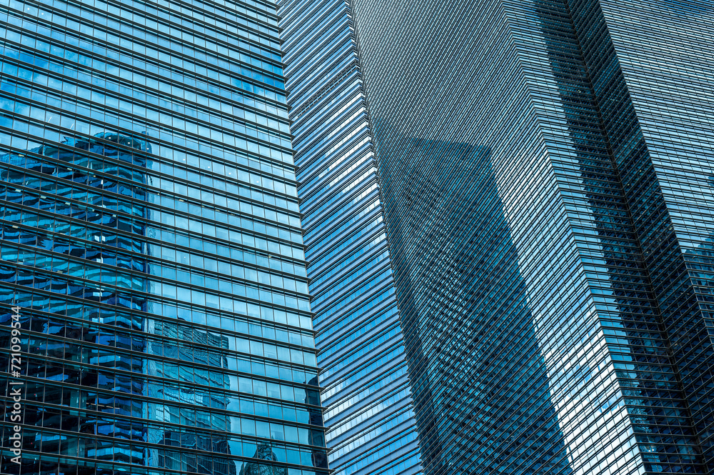 Full-frame shot of modern glass and metal skyscraper facade in cool blue tones. background for financial services and business concepts, featuring sleek and contemporary architectural design