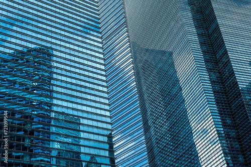 Full-frame shot of modern glass and metal skyscraper facade in cool blue tones. background for financial services and business concepts  featuring sleek and contemporary architectural design