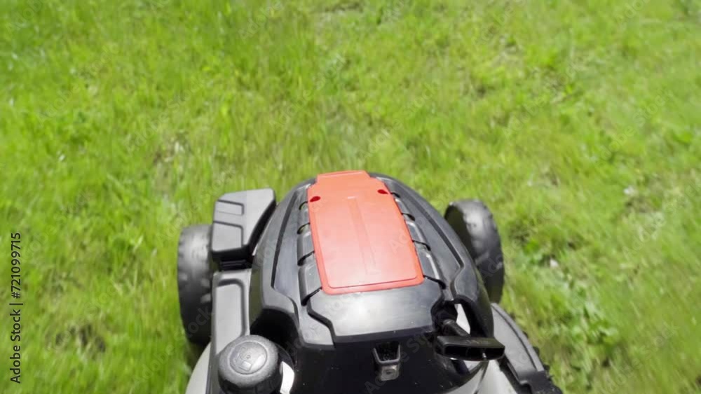 a gardener with a lawn mower mows the lawn a gardener with a lawn mower mows the lawn
