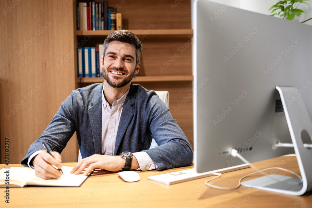 Successful young person in business suit working in his office and smiling. Successful young person in business suit working in his office and smiling.