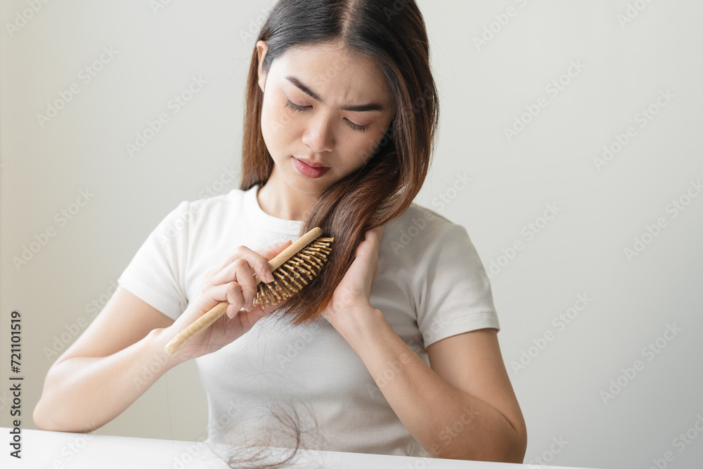 Close-up young woman brushing her hair and have many hair loss on the comb Close-up young woman brushing her hair and have many hair loss on the comb