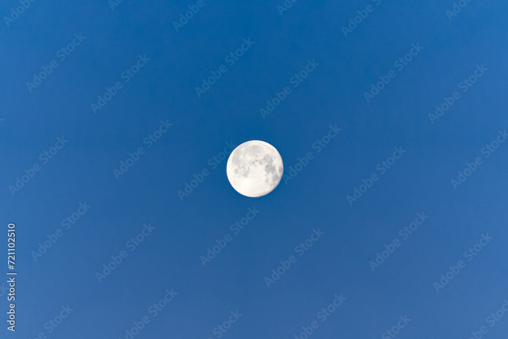 Looking up full moon with blue sky background at sunrise at Swiss City of Zürich on a sunny winter morning. Photo taken January 27th, 2024, Zurich, Switzerland. Looking up full moon with blue sky background at sunrise at Swiss City of Zürich on a sunny winter morning. Photo taken January 27th, 2024, Zurich, Switzerland.