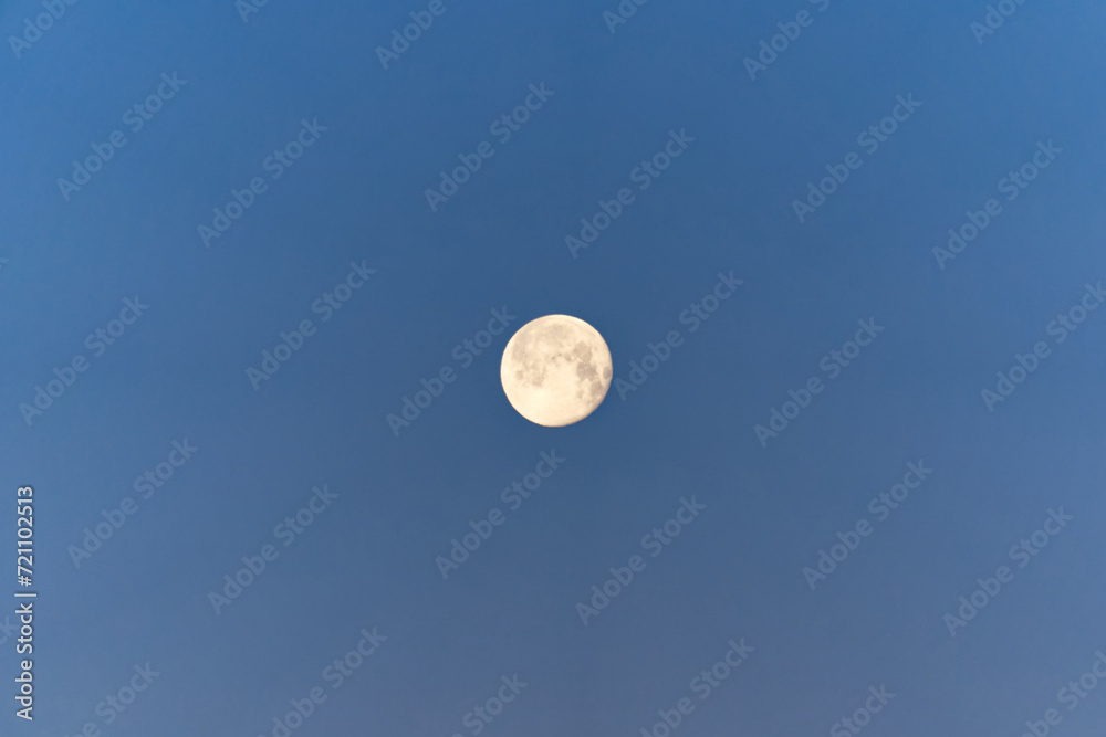 Looking up full moon with blue sky background at sunrise at Swiss City of Zürich on a sunny winter morning. Photo taken January 27th, 2024, Zurich, Switzerland. Looking up full moon with blue sky background at sunrise at Swiss City of Zürich on a sunny winter morning. Photo taken January 27th, 2024, Zurich, Switzerland.