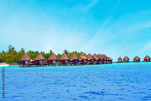 Water villas stand abreast in Maldivian sea 5