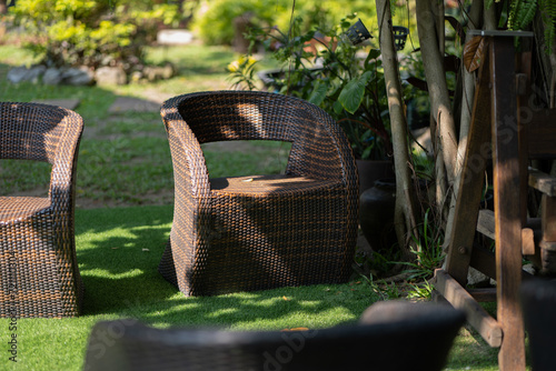 Photo of  rattan chair and wooden table  in garden , Thailand.