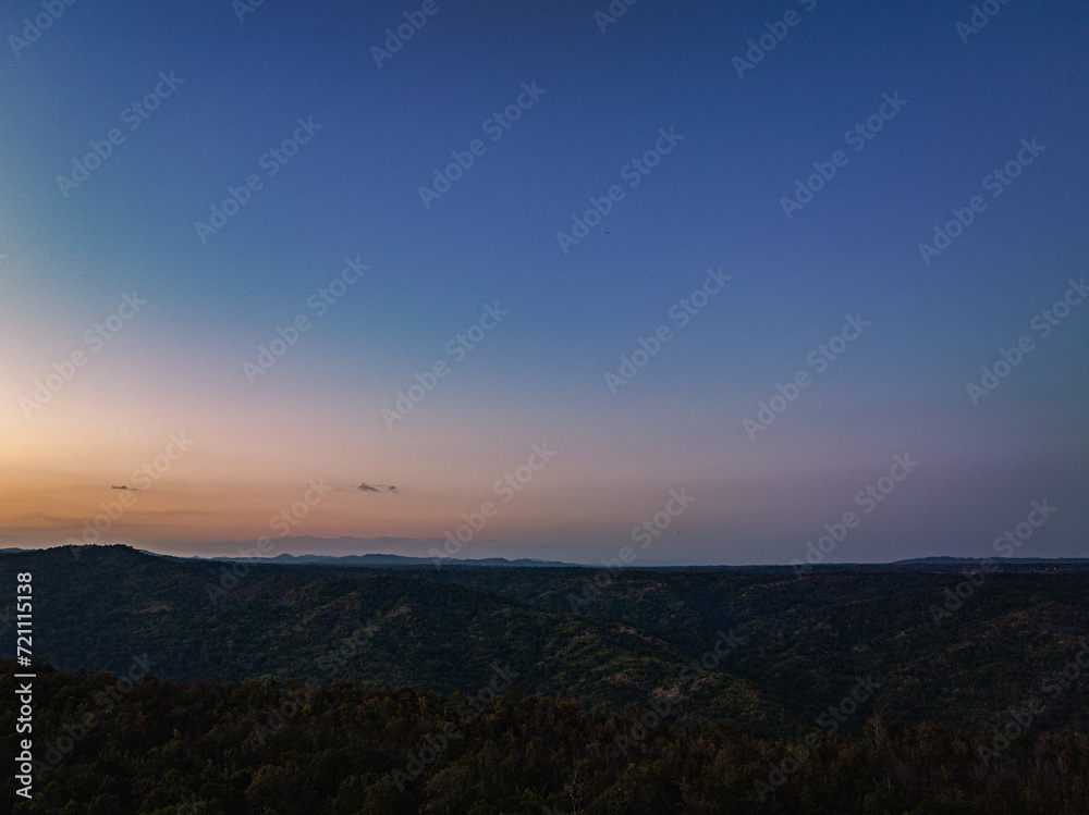 Aerial view A breathtaking sunset paints the sky with vibrant hues of orange and red, .casting a warm glow over the majestic mountains in a tranquil evening landscape. Aerial view A breathtaking sunset paints the sky with vibrant hues of orange and red, .casting a warm glow over the majestic mountains in a tranquil evening landscape.