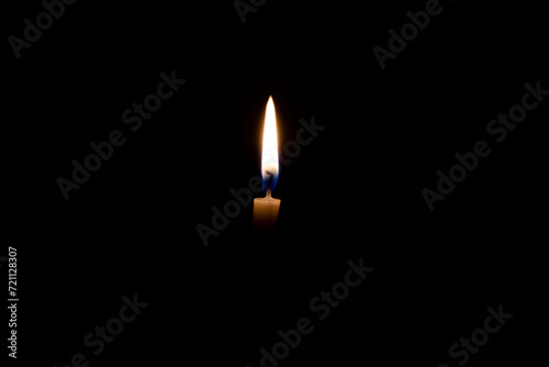 white burning candle on a black background