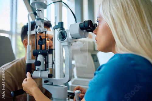 Medical expert during eye exam of her patient at ophthalmology clinic