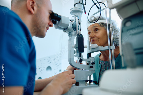 Senior woman during eye and vision exam at ophthalmologist's. photo
