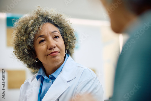 Black female doctor communicating with patient in hospital. photo