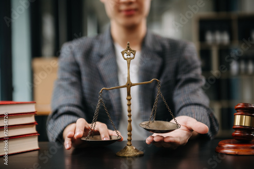 Male lawyer in the office with brass scale on wooden table. justice and law concept in morning light photo