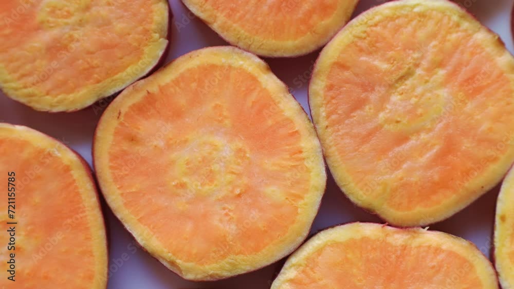 Fresh orange sweet potato slices circle rotation close up top view Fresh orange sweet potato slices circle rotation close up top view