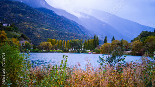 Fototapeta Naklejka Na Ścianę i Meble -  Autumn foliage and fog lake in morning with mountains behind