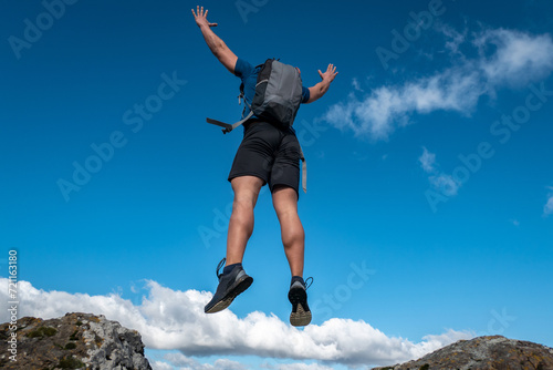 Aventureiro ativo: A jornada vital de um jovem desportista com a mochila às costas, elevando-se a nas alturas no alto pico montanhoso