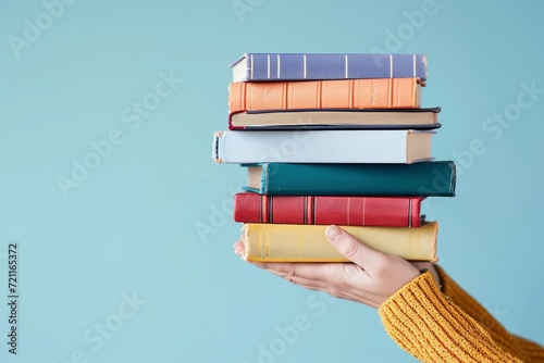 Female hands holding pile of books over light blue background. Education, self-learning, book swap, hobby, relax time, Generative AI