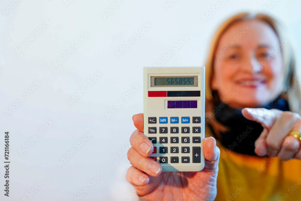 A senior woman showing the camera a white calculator with copy space A senior woman showing the camera a white calculator with copy space