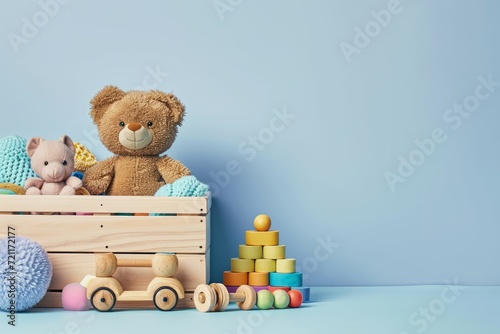 Toy box full of baby kid toys. Container with teddy bear, wooden rattles, stacking pyramid and wood blocks on light blue background. Cute toys collection for small children. Donatation. Generative AI © Morningmaze