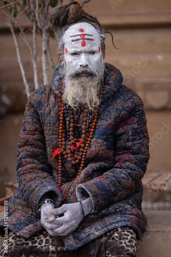 Portrait of an holy sadhu baba with ash on his face sitting on ghats near river ganges.