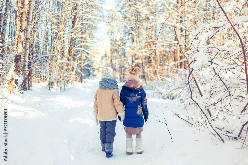 Children walk in a winter snowy forest.