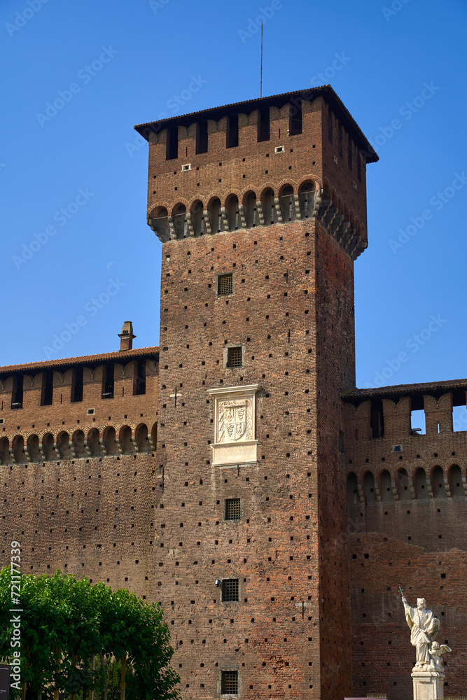 Fortified wall and tower with turrets at the Castello Sforzesco (Sforzesco Castle) on a clear sunny fall day in Milan, Italy
