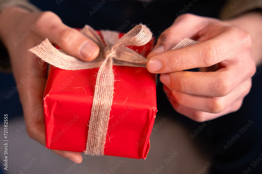  Valentine's Day.Close-up The young man opens a gift that his partner gives him.