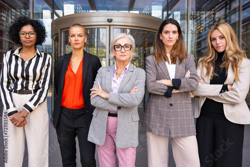 Team of multiracial and diverse businesswomen led by boss posing seriously for the camera.