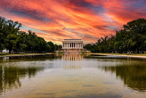 The Abraham Lincoln Memorial Temple reflected in the reflecting pool under an orange sky at sunset, located on the National Mall in Washington DC, USA.