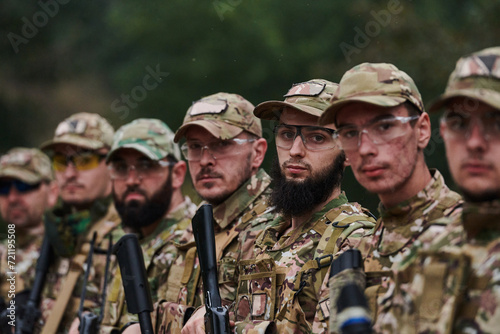 Soldier fighters standing together with guns. Group portrait of US army elite members, private military company servicemen, anti terrorist squad