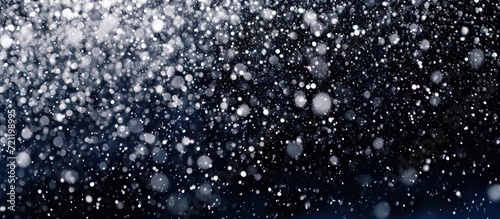 Snowstorm stock image with falling snow on black background.