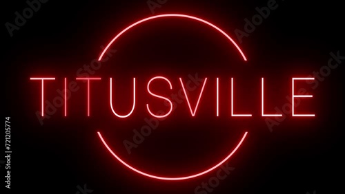 Flickering red retro style neon sign glowing against a black background for TITUSVILLE photo