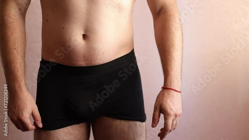 Guy with naked torso takes off his jeans and strips down to his underpants. Passing commission at military registration and enlistment office photo