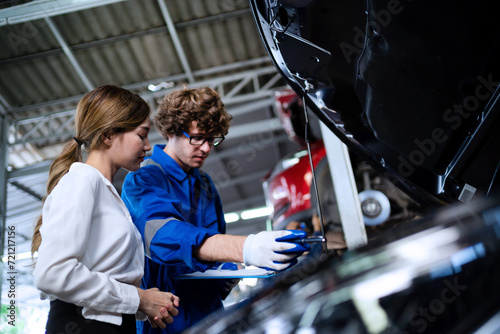 auto mechanic in garage A car service worker inspects the condition of the car in the factory. service concept in a car garage consultation Maintenance service.