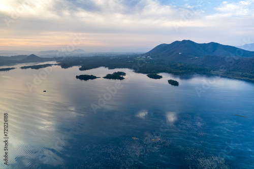 Aerial drone shot showing sunrise dawn dusk over aravalli hills lake pichola fateh sagar and cityscape in Udaipur, Chandigarh, Nainital showing famous tourist spot