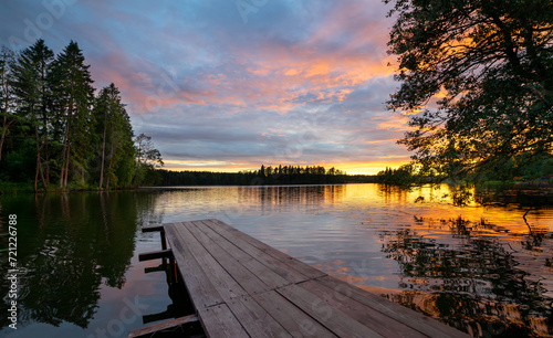 Sunset on a forest lake in summer.A great place to relax by the water. Fresh air in nature.Summer fishing.A wooden bridge on the lake.