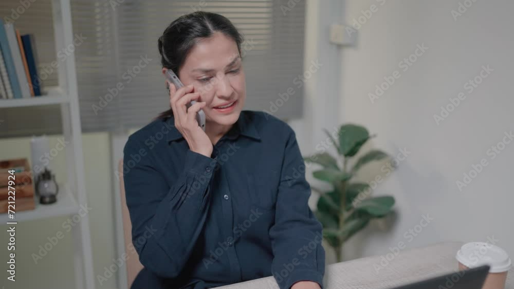 Young woman talking on the phone using laptop sitting at table at home, happy female customer calling on mobile to confirm online delivery concept. Young woman talking on the phone using laptop sitting at table at home, happy female customer calling on mobile to confirm online delivery concept.
